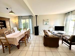 een woonkamer met een tafel en een bank bij Maison de vacances – Jardin – 5 min des plages in Guidel