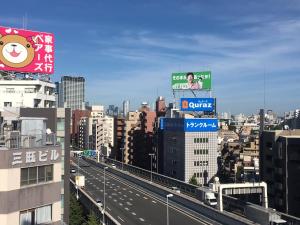 a city with a sign on top of a highway at 10 minutes direct to Shibuya Crossing! Heart of Tokyo! Mishuku in Tokyo