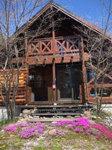 a log cabin with flowers in front of it at Aki in Hakuba
