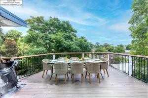 una terraza de madera con mesa y sillas. en Entire Nelson Bay home walk to the Beach and Town Centre en Nelson Bay