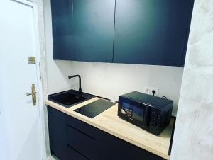 a kitchen counter with a microwave and a sink at BALCON PLAYA Y PARKING Puerta Mar PONDOS in Almuñécar
