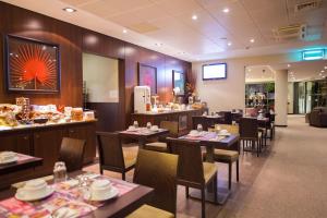 a restaurant with tables and chairs and a bar at Hotel du Pasino in Saint-Amand-les-Eaux