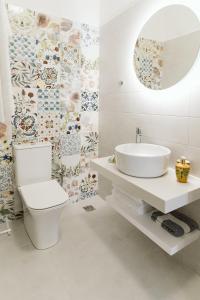 a bathroom with a white toilet and a sink at Villa Limnes in Perissa