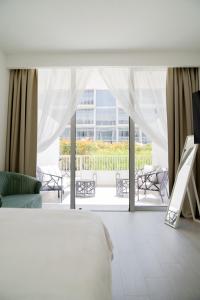 Postel nebo postele na pokoji v ubytování Modern Studio with a Garden View & Big Outdoor Terrace (JVC)