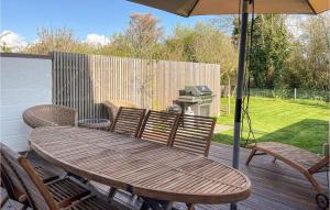 a wooden table and chairs with an umbrella on a deck at Awesome Home In Viken With Wifi And 2 Bedrooms in Viken