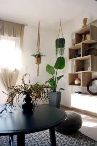 a living room with a table and some plants at Cosy Cave Apartment by the sea in Loutraki