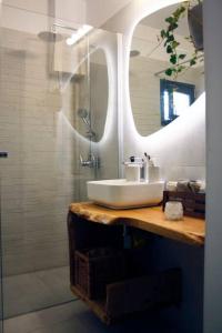 a bathroom with a sink and a shower with a mirror at Cosy Cave Apartment by the sea in Loutraki