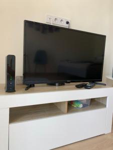 a large flat screen tv sitting on a white entertainment center at Világos, kellemes lakás, jó közlekedéssel in Budapest