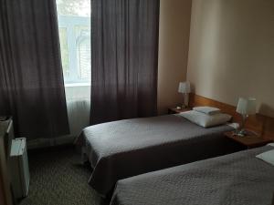 a hotel room with two beds and a window at Hotel Yes in Narva-Jõesuu