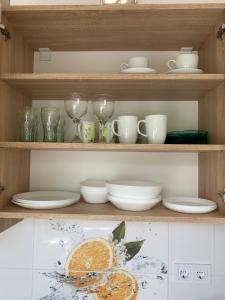 a shelf with plates and cups and glasses on it at Világos, kellemes lakás, jó közlekedéssel in Budapest