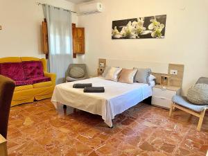 1 dormitorio con cama y sofá amarillo en Casa de Huéspedes , Villa Adriana, en Jávea