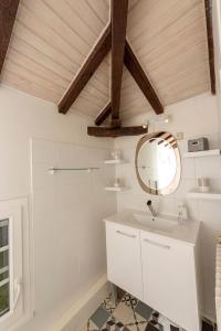 a bathroom with a white sink and a mirror at LE GITE du REFUGE du PEINTRE proche de St Emilion in Sainte-Terre