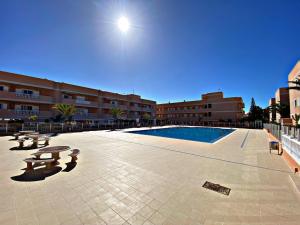 un gran patio con piscina, mesas y edificios en Costa Sol, 1 bedroom apartment., en Arona