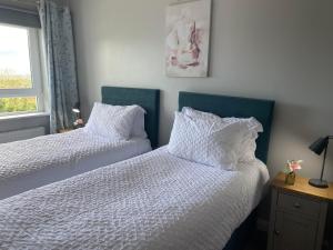 a bedroom with two beds with white sheets and a window at Hastings Apartments Extra Large Self Catering Apt Tourism Certified Free Parking WiFi in Belfast