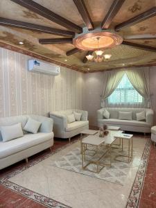 a living room with two couches and a table at Alamjed Residence in Mecca