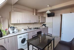 a kitchen with a table and a sink and a dishwasher at Apartament in Timisoara in Timişoara