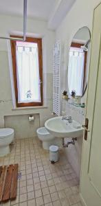 bagno con lavandino, servizi igienici e specchio di I Pini House a Magione