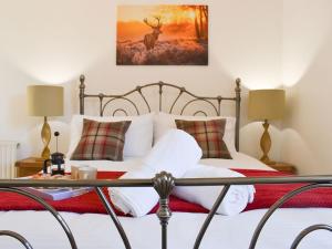 um quarto com uma cama com uma pintura de veado na parede em Karslake Cottage em Winsford