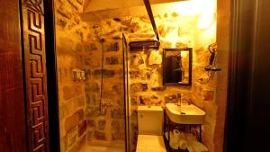 ein Bad mit einer Dusche und einem Waschbecken in der Unterkunft AĞAOĞLU HAN OTEL in Mardin