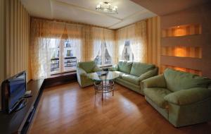 ein Wohnzimmer mit 2 grünen Sofas und einem TV in der Unterkunft PARKOVY apart in Truskawez