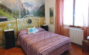 マジョーネにあるI Pini Houseのベッドルーム1室(壁に絵画が描かれたベッド1台付)