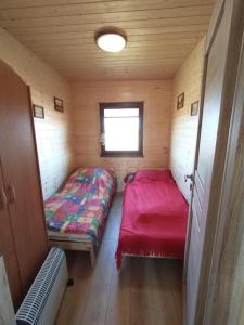 a small room with two beds and a window at Domek na wyłączność LAWENDA in Jezierzany