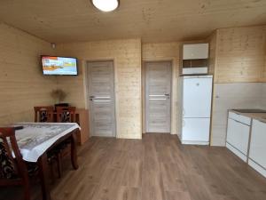 a kitchen with a table and a white refrigerator at Domek na wyłączność LAWENDA in Jezierzany
