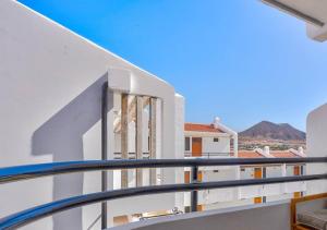 a balcony of a building with a view of the mountains at Stylish flat and pool with 3 rooms, sleeps 6, Los cristianos in Los Cristianos