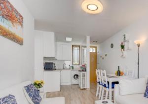 a kitchen and a living room with a couch and a table at Stylish flat and pool with 3 rooms, sleeps 6, Los cristianos in Los Cristianos