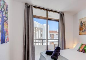 a bedroom with a bed and a large window at Stylish flat and pool with 3 rooms, sleeps 6, Los cristianos in Los Cristianos
