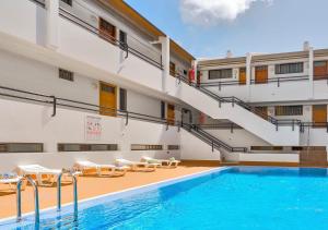 a hotel with a swimming pool and stairs at Stylish flat and pool with 3 rooms, sleeps 6, Los cristianos in Los Cristianos