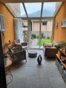 sala de estar con muebles y ventana grande en Ampie camere con balcone giardino e piscina, en Gordola