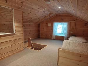 una camera da letto in una baita di tronchi con un letto e una finestra di Hytte ved Vråvatnet i Vrådal a Sinnes
