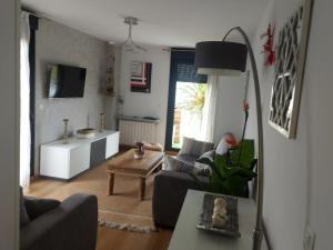 Una sala de estar con dos sofás y una mesa. en Alojamientos Marte apartamento a pie de playa y garaje, en Suances