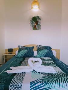 una cama con una decoración de cisne en ella en Cibuqueira numéro 7, Centre ville, vue sur mer , plage à pied, en Le Moule