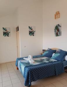 1 dormitorio con 1 cama con manta azul en Cibuqueira numéro 7, Centre ville, vue sur mer , plage à pied, en Le Moule