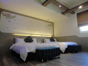 two beds in a room with a large painting on the wall at Royal Hotel in Magong
