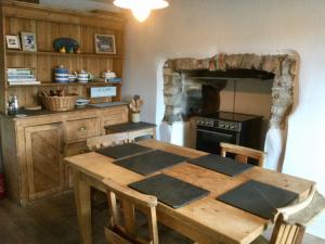 una cucina con un tavolo di legno e una stufa di Cosy Cottage in Lovely Georgeham a Georgeham