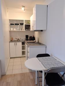 une petite cuisine avec des placards blancs et une table dans l'établissement Studio calme Brest hyper centre, à Brest