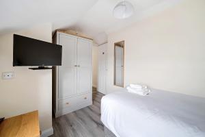 a white bedroom with a bed and a flat screen tv at Carlisle Lodge 'Sleeping 6 guests' in Derry Londonderry