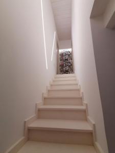 una scala in una casa con pareti bianche e soffitti bianchi di retroscena matrimoniale in centro a Civitanova Marche