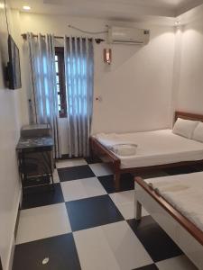 ein Zimmer mit zwei Betten und einem Schachbrettboden in der Unterkunft VeLa Homestay in Phu Quoc