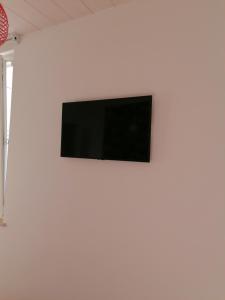 una TV a schermo piatto su una parete bianca di retroscena matrimoniale in centro a Civitanova Marche