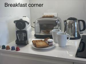 een ontbijtbar met toast en koffiekopjes en een broodrooster bij Izaro Apartamento Atico de Lujo cerca de Playa Dorada in Playa Blanca