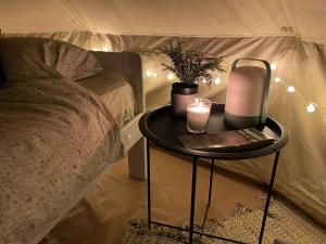 a table with a candle on it next to a bed at Paluküla Glamping Kase in Paluküla