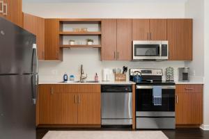 a kitchen with wooden cabinets and stainless steel appliances at Sweet Tart Spot - Cozy TC Condo - Pet Friendly in Traverse City