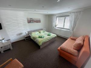 ein Schlafzimmer mit einem Bett, einem Sofa und einem Fenster in der Unterkunft Apartmány pri Zvonici in Oravský Podzámok