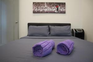 Una cama con almohadas de ganchillo púrpura. en Dudu Guesthouse Kuala Kangsar, en Kuala Kangsar