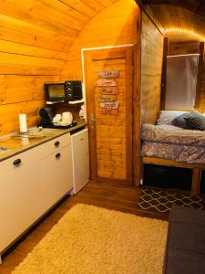 Una habitación con cocina y una cama en una cabaña en Gallas Pod House en Vouzela