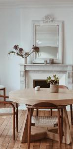- une salle à manger avec une table et un miroir dans l'établissement Maison Lùisa, à Autun